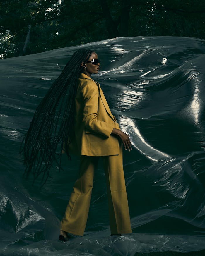 Stylish woman in yellow suit captured against dramatic background in Córdoba, Spain.